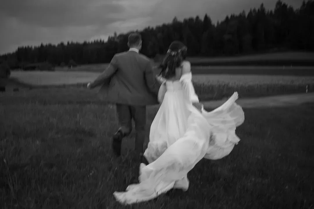 Brautpaar rennt durch das Feld, Schwarzweiß